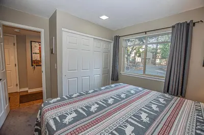 a bedroom with a bed and a large window at Lake Forest Glen # 117 By Hauserman Rentals in Tahoe City