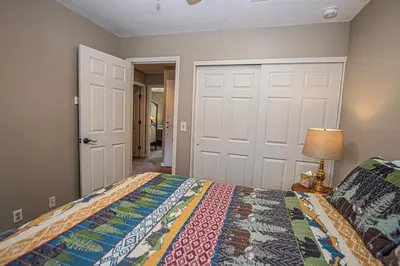 a bedroom with a bed and a lamp and a door at Lake Forest Glen # 117 By Hauserman Rentals in Tahoe City