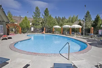 a large swimming pool with chairs and umbrellas at Lake Forest Glen # 117 By Hauserman Rentals in Tahoe City