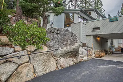 a house with a stone wall next to a building at KT22 View By Hauserman Rentals in Olympic Valley