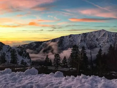 a mountain covered in snow with trees and clouds at Cozy Condo with Fireplace - Tamarack 3 in Bear Valley