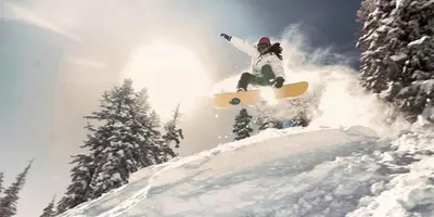 a person doing a trick on a snowboard in the air at Cozy Condo with Fireplace - Tamarack 3 in Bear Valley
