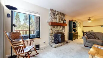 a living room with a stone fireplace and a couch at Summit #243 condo in Mammoth Lakes