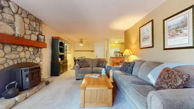 a living room with a couch and a stone fireplace at Summit #243 condo in Mammoth Lakes