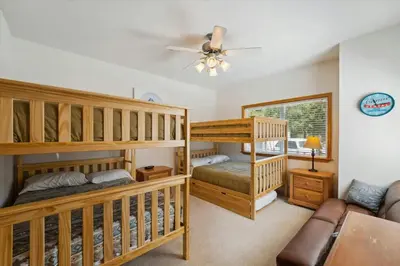 a bedroom with two bunk beds and a couch at Olympic Pines Lodge in Olympic Valley