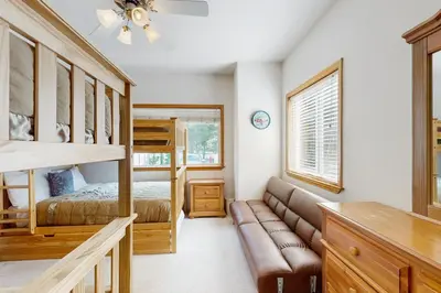 a bedroom with a bunk bed and a couch at Olympic Pines Lodge in Olympic Valley