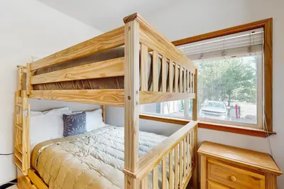 a wooden bunk bed in a room with a window at Olympic Pines Lodge in Olympic Valley
