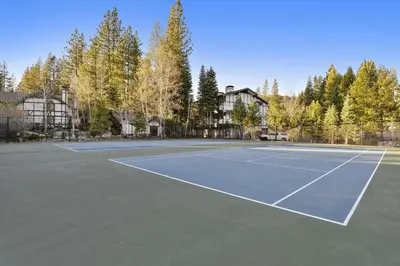 a tennis court in front of a house at Olympic Pines Lodge in Olympic Valley