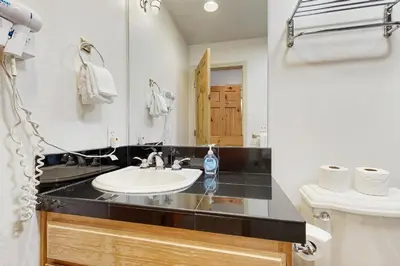 a bathroom with a sink and a toilet and a mirror at Olympic Pines Lodge in Olympic Valley