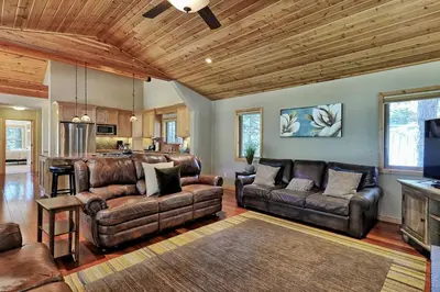 a living room with leather couches and a kitchen at Tahoma Family Home in Tahoma