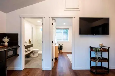 a bathroom with a toilet and a television on a wall at Columbia Cabins Cabin 1 in Sonora