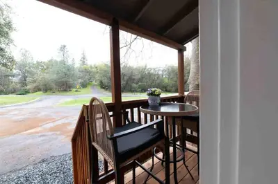 a screened in porch with a table and chairs at Columbia Cabins Cabin 2 in Sonora