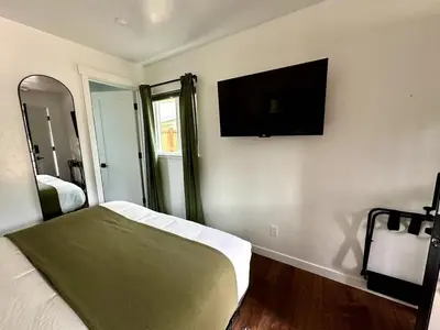 a bedroom with a bed and a flat screen tv on the wall at Columbia Cabins Cabin 2 in Sonora