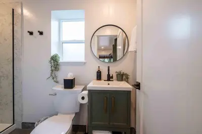 a bathroom with a toilet and a sink and a mirror at Columbia Cabins Cabin 3 in Sonora
