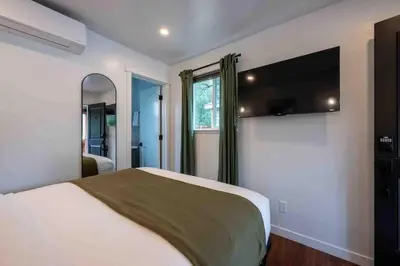 a bedroom with a bed and a flat screen tv at Columbia Cabins Cabin 3 in Sonora