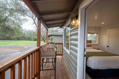 a porch of a house with a bed and a bedroom at Columbia Cabins Cabin 4 in Sonora