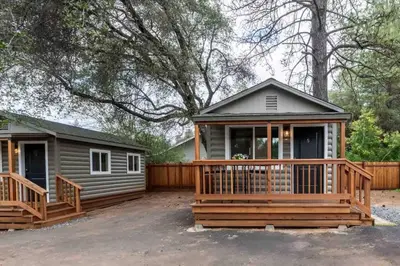 a home with a large deck and a house at Columbia Cabins Cabin 5 in Sonora