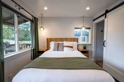 a bedroom with a large bed and a large window at Columbia Cabins Cabin 5 in Sonora