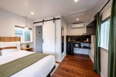 a bedroom with a large bed and a kitchen at Columbia Cabins Cabin 5 in Sonora