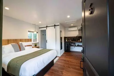 a bedroom with a large bed and a kitchen at Columbia Cabins Cabin 5 in Sonora