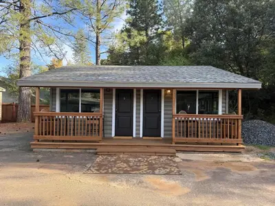 a small house with a porch and a roof at Columbia Cabins Cabin 6 in Sonora