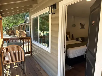 a porch of a house with a bed and a bedroom at Columbia Cabins Cabin 6 in Sonora