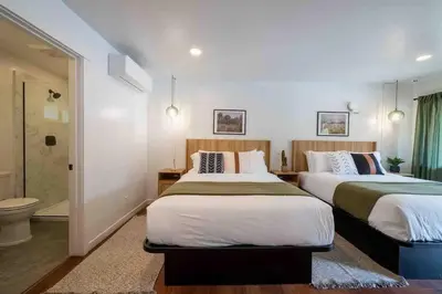 a bedroom with two beds and a bathroom with a toilet at Columbia Cabins Cabin 7 in Sonora