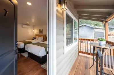 a room with a bed and a balcony at Columbia Cabins Cabin 7 in Sonora