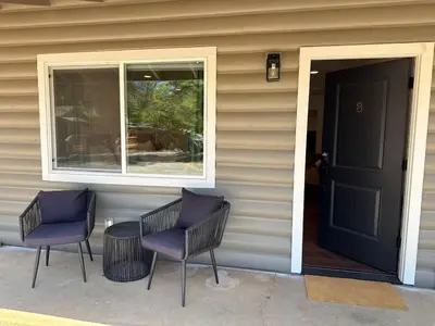 two chairs and a table in front of a house at Columbia Cabins Cabin 8 in Sonora