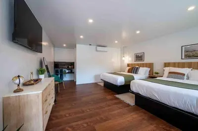a bedroom with two beds and a flat screen tv at Columbia Cabins Cabin 9 in Sonora