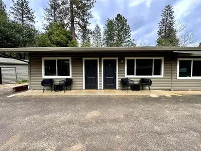 a small house with black chairs in front of it at Columbia Cabins Cabin 9 in Sonora