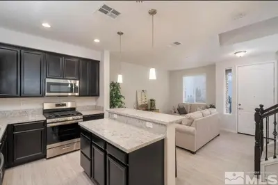 a kitchen with black cabinets and a living room at Local 3BD 3BA with WiFi Parking in Carson City