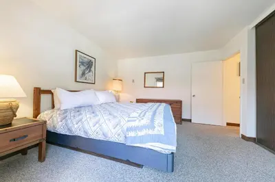 a bedroom with a bed and a dresser and a lamp at Spacious 1BR Condo #218 at Donner Lake Village in Truckee