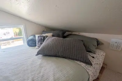 a bed with pillows on it in a bedroom at 11 Mi to Heavenly Resort Pet-Friendly Tiny Home in Gardnerville