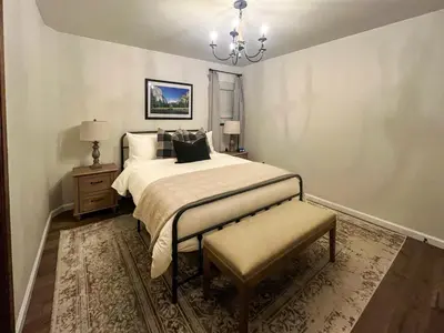 a bedroom with a large bed and a chandelier at Yosemite Family Lodge I Sleeps 11 I Game Room in Oakhurst