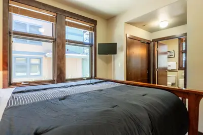 a bedroom with a large bed and a window at Solstice 8 in Mammoth Lakes