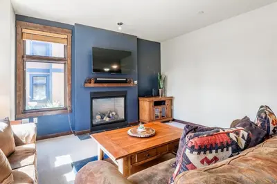 a living room with a couch and a fireplace at Solstice 8 in Mammoth Lakes