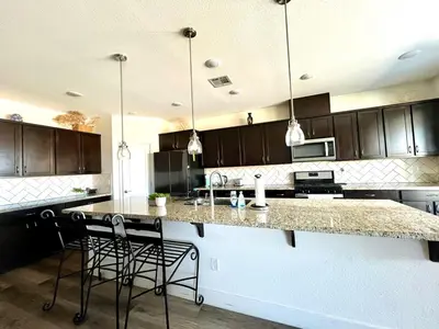 a kitchen with a counter and some chairs in it at Spacious, bright and cozy space