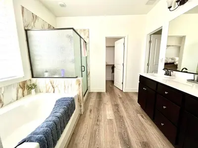 a bathroom with a large tub and a sink and a tub at Spacious, bright and cozy space
