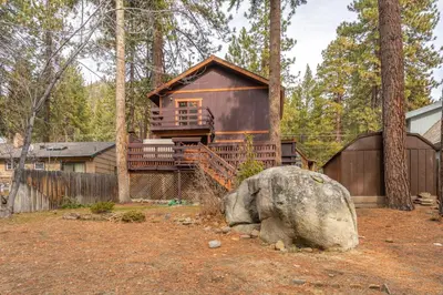 a cabin in the woods with a large rock at Lakeside Serenity Retreat in Kings Beach