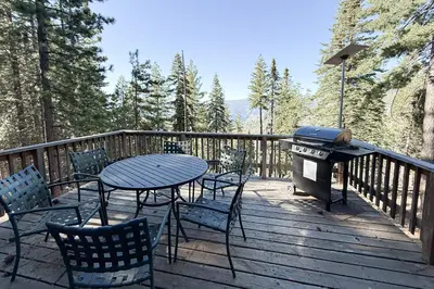 a table and chairs on a deck with a grill at Vernal Vista in Yosemite West