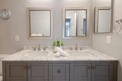 a bathroom with two sinks and two mirrors at New Reno Retreat 72 Inch TV Office Patio Views in Reno