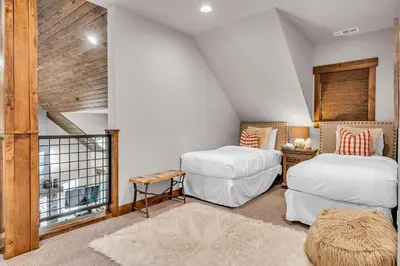 a attic bedroom with two beds and a window at Schaffers Mill Escape Golf Views and Near Skiing in Truckee