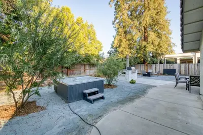 a backyard with a hot tub and a table and chairs at Clovis Retreat Hottub & Firepit in Clovis