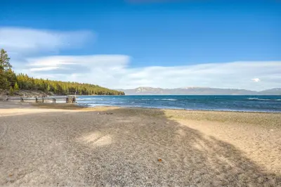 a beach with a picnic table and the water at Blue Lake Bliss in Tahoe City