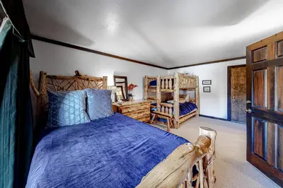 a bedroom with a wooden bed with a blue comforter at Tavern 16 in Olympic Valley