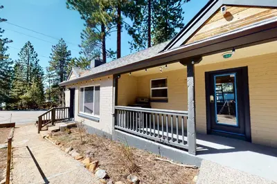 a yellow house with a porch and a door at The Chalet at Kings Beach Unit 8 in Kings Beach