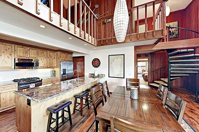 a kitchen with a table and chairs and a staircase at Lake Tahoe Oasis in Kings Beach
