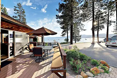 a patio with a table and chairs and an umbrella at Lake Tahoe Oasis in Kings Beach