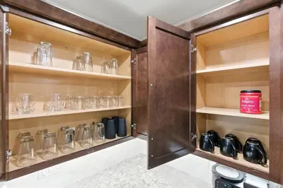 a wine cellar with wooden shelves with glasses at The White House Coveted Triplex Near Lake